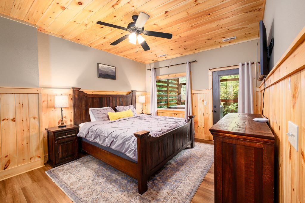 Wood-paneled king bedroom at a vacation rental in the Smoky Mountains.