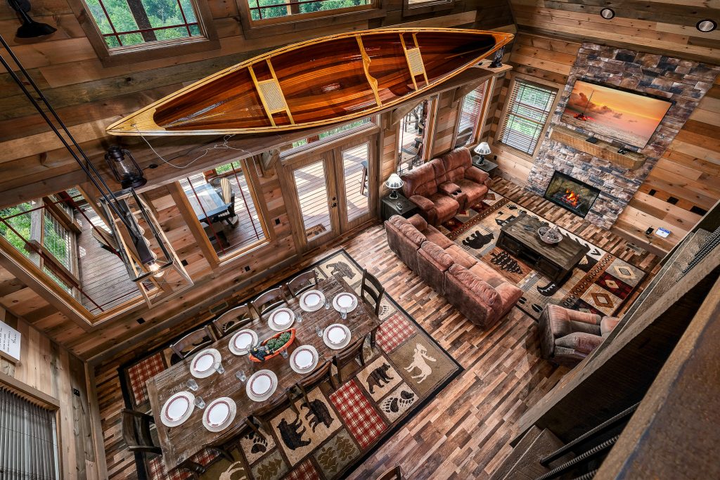 Open log cabin living and dining room from loft at a vacation rental in the Smoky Mountains.