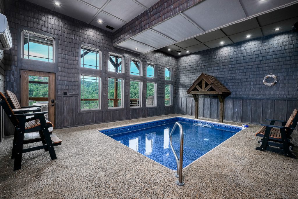 Indoor swimming pool with stone waterfall at a vacation rental in the Smoky Mountains.