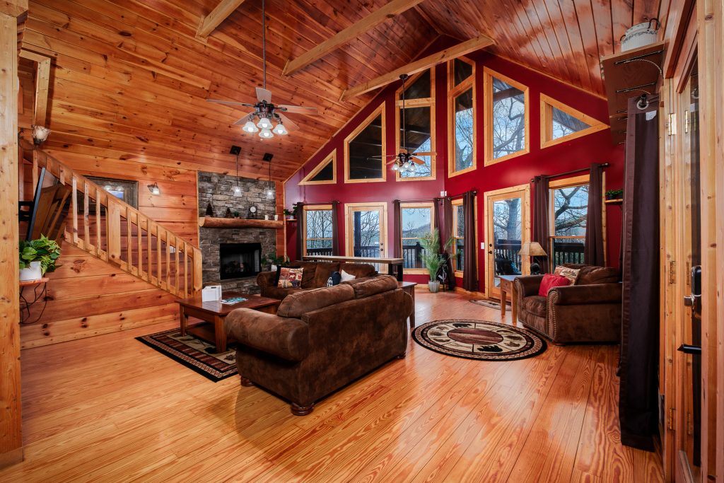 Log cabin great room with stone fireplace at a vacation rental in the Smoky Mountains.