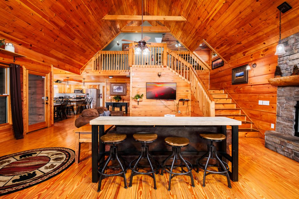 Log cabin breakfast bar and open living room at a vacation rental in the Smoky Mountains.