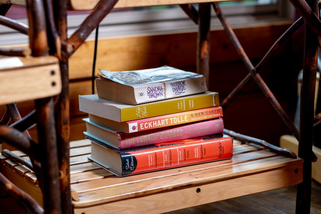 Stack of novels on a woven chair in a Smoky Mountains cabin.