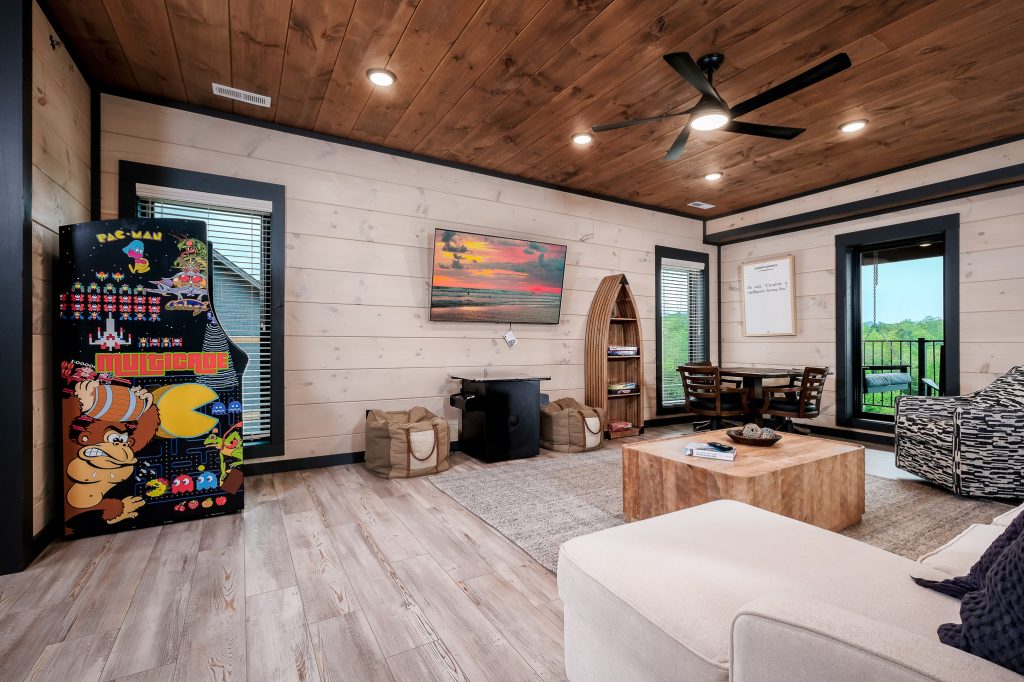Modern cabin game room with arcade at a vacation rental in Sevierville, Tennessee.