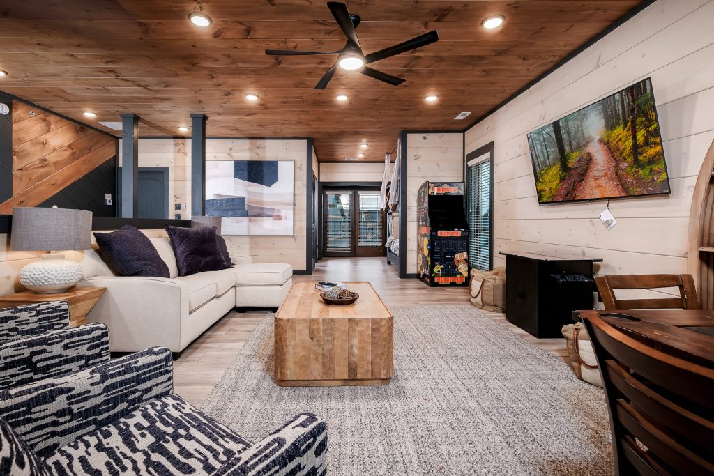 Modern cabin living room with fireplace and arcade at a vacation rental in Sevierville, Tennessee.