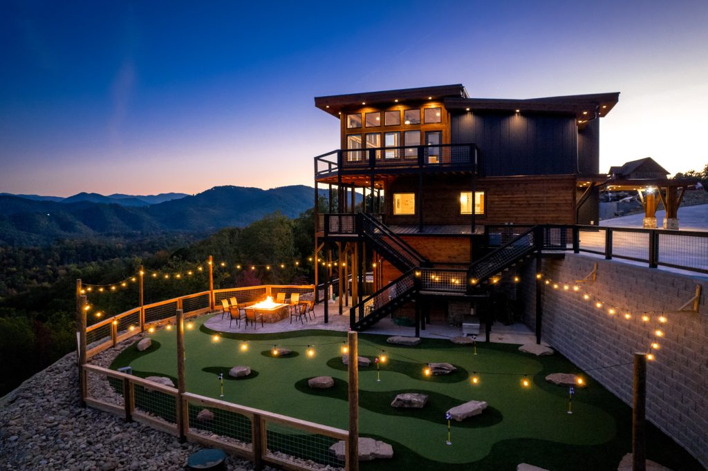 Mountain-view putting green and cabin at twilight at a vacation rental in Wears Valley in the Smoky Mountains.