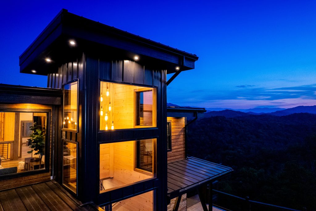 Glass tower cabin overlooking the Smokies at dusk at a vacation rental in Wears Valley in the Smoky Mountains.