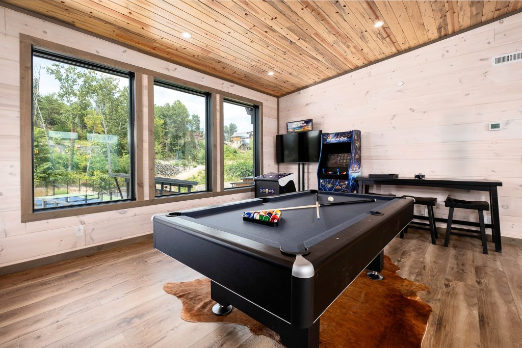 Game room with pool table and arcade at a vacation rental in Wears Valley in the Smoky Mountains.
