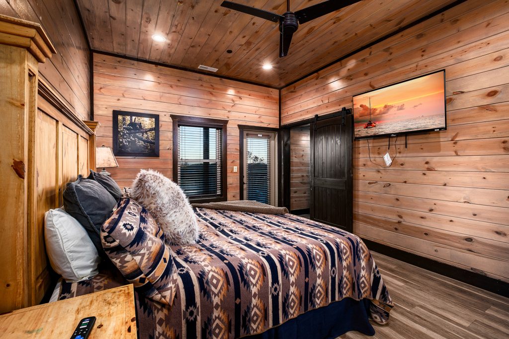 Rustic bedroom with leather headboard at a vacation rental in Wears Valley in the Smoky Mountains.