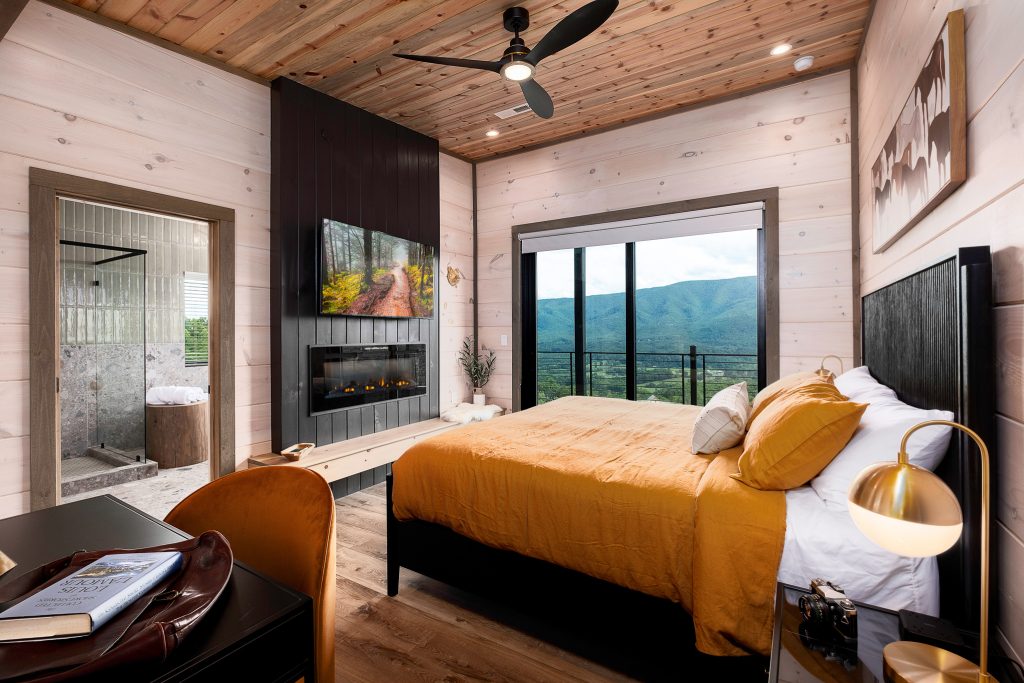 Orange-accent king bedroom with mountain view at a vacation rental in Wears Valley in the Smoky Mountains.