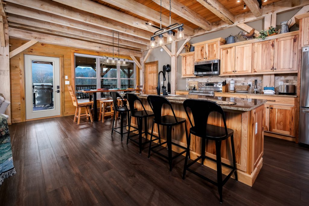 Rustic kitchen with a long breakfast bar and exposed timber framing.