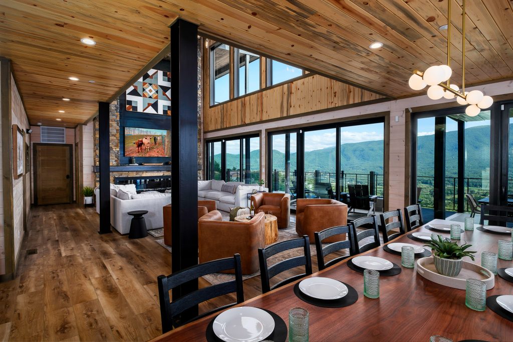 Open dining and living area framed by floor-to-ceiling mountain windows.