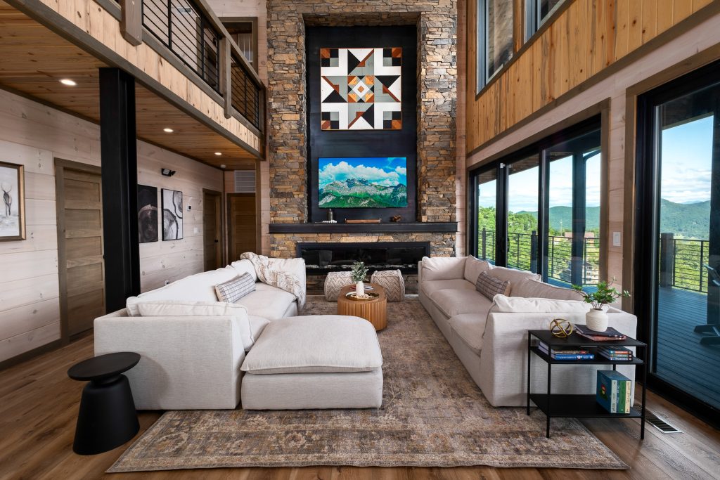 Double-height living room and stone fireplace at a vacation rental in Wears Valley in the Smoky Mountains.