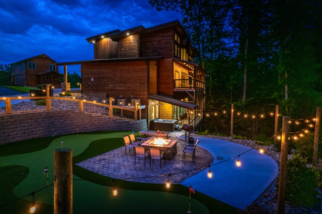 Cabin putting green and fire pit at twilight at a vacation rental in Pigeon Forge, Tennessee.