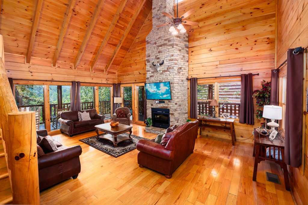 Log cabin great room with stone fireplace at a vacation rental in Pigeon Forge, Tennessee.