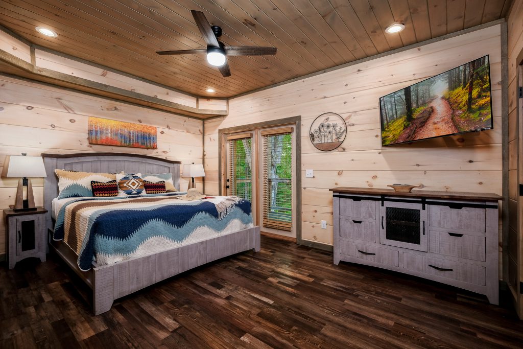 Blue-accent king bedroom with fireplace at a vacation rental in Pigeon Forge, Tennessee.