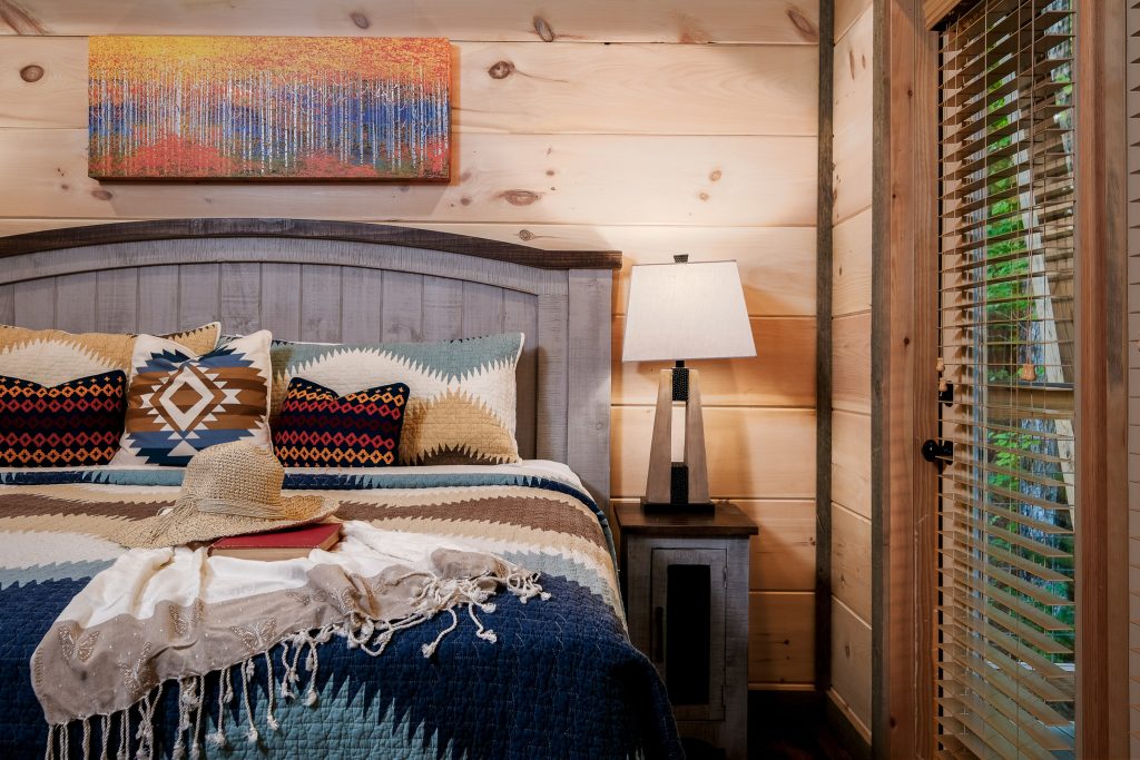 Styled king bed with geometric pillows at a vacation rental in Pigeon Forge, Tennessee.