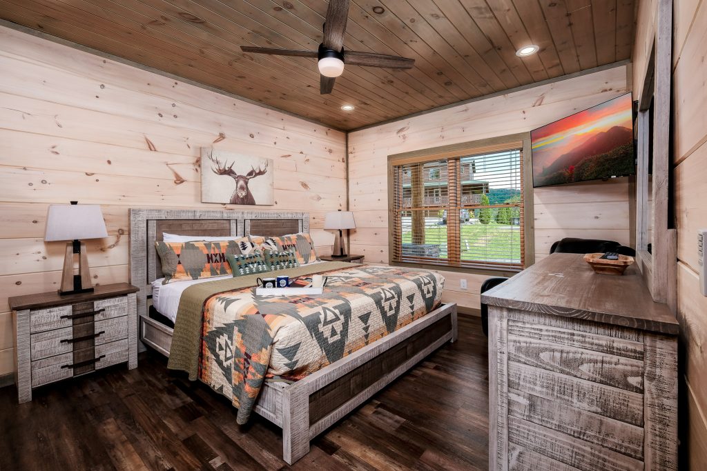 Rustic king bedroom with colorful quilt at a vacation rental in Pigeon Forge, Tennessee.