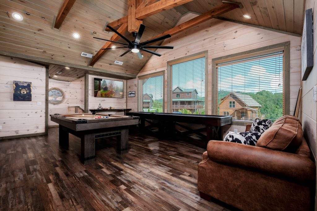 Game room with pool table and picture windows at a vacation rental in Pigeon Forge, Tennessee.