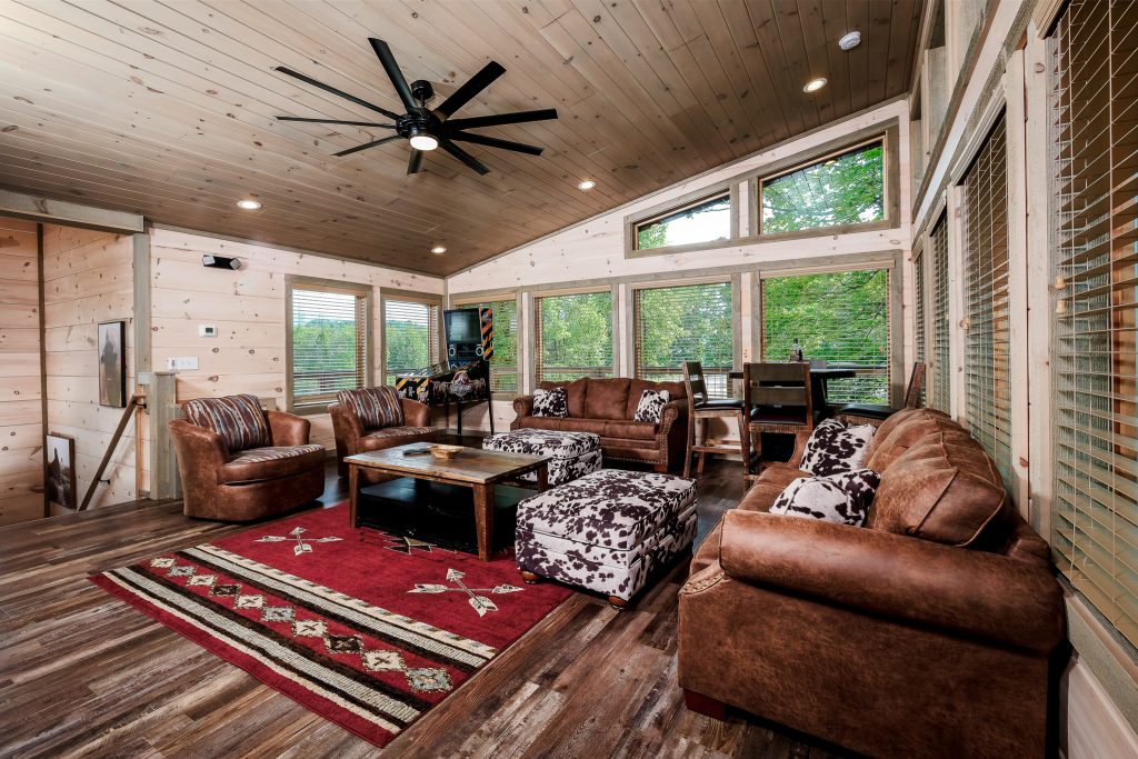Cabin living room with forest windows at a vacation rental in Pigeon Forge, Tennessee.