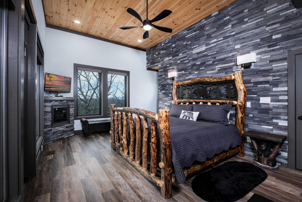 Log bed and black stone fireplace at a vacation rental in Gatlinburg, Tennessee.