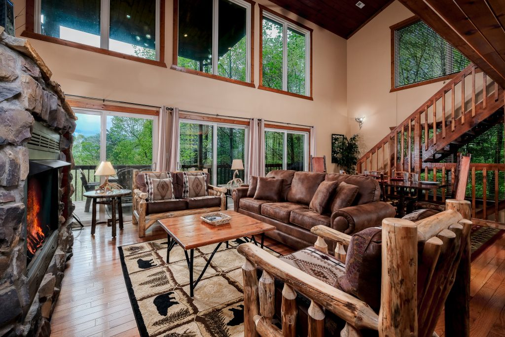 Open living and dining room with forest windows at a vacation rental in Gatlinburg, Tennessee.