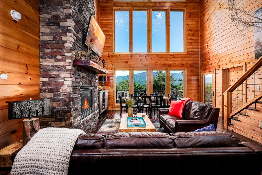 Log great room with mountain windows and fireplace at a vacation rental in Gatlinburg, Tennessee.