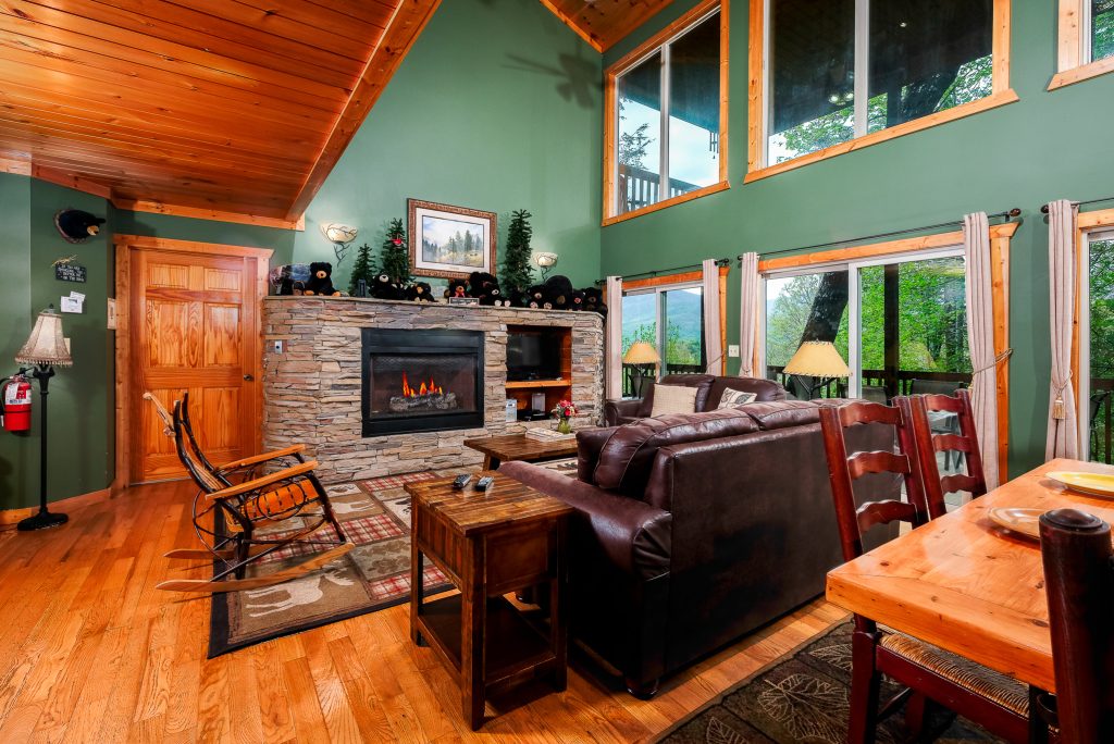 Green cabin living room and dining area at a vacation rental in Gatlinburg, Tennessee.